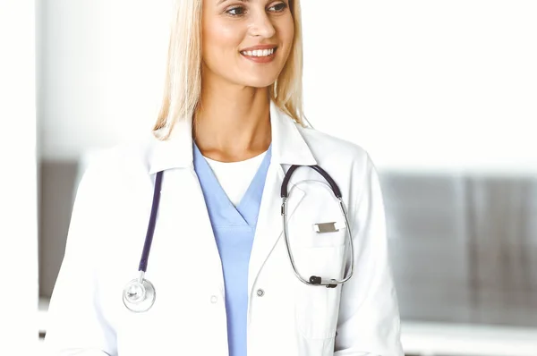 A kórházban dolgozó nő-orvos boldogan kommunikál a női beteggel. A szőke orvos ellenőrzi a kórtörténetét és a vizsgaeredményeit. Orvosi fogalom — Stock Fotó