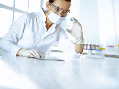 Kadın laboratuvar asistanı hastanede kan örneğini inceliyor. Tıp, sağlık ve araştırma konsepti