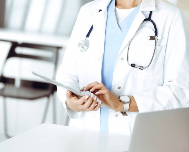 Klinikte çalışan kimliği belirsiz kadın doktor. Tablet bilgisayar kullanan kadın doktor, yakın plan. Tıp konsepti