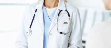 Bilinmeyen kadın-doktor kadın hastayla iletişim kuruyor. Doktor tıbbi geçmişi ve muayene sonuçlarını yakından kontrol ediyor. Tıp konsepti