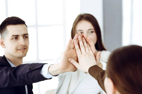 チームワークを発揮し、手をつなぎ、または現代のオフィスで5つを与えるビジネスの人々グループ。無名のビジネスマンや女性が手で輪になって — ストック写真