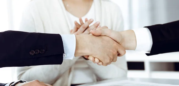 Zakenmensen schudden elkaar de hand na het tekenen van een contract in een modern kantoor. Teamwork en handdruk concept — Stockfoto