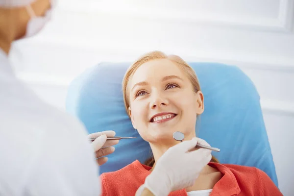 Una donna caucasica sorridente e 'stata visitata dal dentista alla clinica dentistica di Sunny. Denti sani e medicina, concetto di stomatologia — Foto Stock