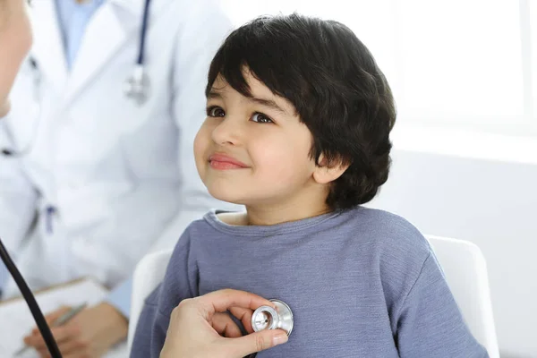 Docteur-femme examinant un enfant patient par stéthoscope. Joli garçon arabe sur rendez-vous chez le médecin. Concept de médecine — Photo