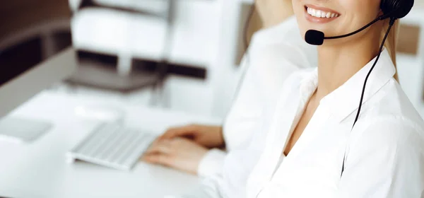 Desconocido representante de servicio al cliente femenino está consultando a los clientes en línea utilizando headset.close-up. Call center y concepto de negocio — Foto de Stock