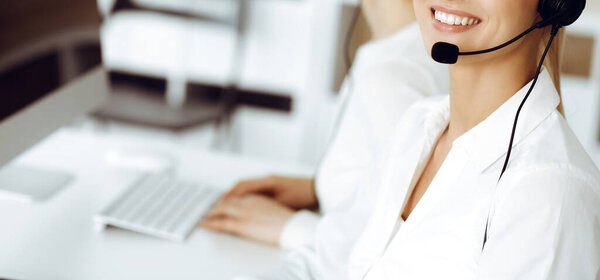 Неизвестная женщина представитель службы поддержки клиентов консультирует клиентов в Интернете с помощью headset.close-up. Телефонный центр и бизнес-концепция