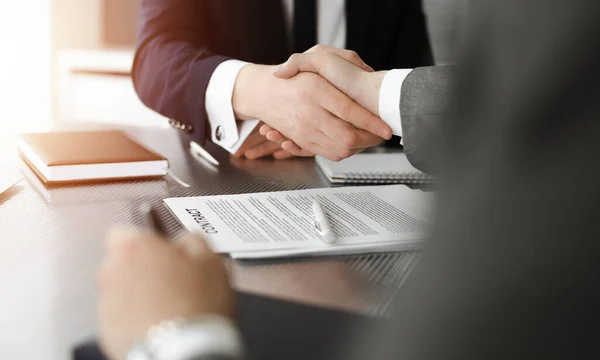 Onbekende zakenman schudt handen met zijn collega of partner boven het bureau in zonnig kantoor, close-up — Stockfoto