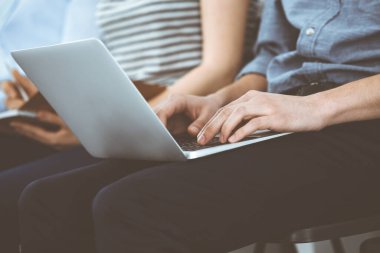 Toplantı ya da konferansta çalışan sıradan giyinmiş iş adamları, ellerinizi yakın tutun. Dizüstü bilgisayar kullanan bir iş adamı. Takım çalışması ya da koçluk kavramı