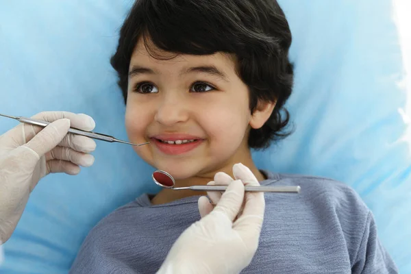 Cute árabe menino sentado na cadeira dentária com a boca aberta durante a verificação oral com o médico. Consulta ao dentista. Conceito de estomatologia — Fotografia de Stock