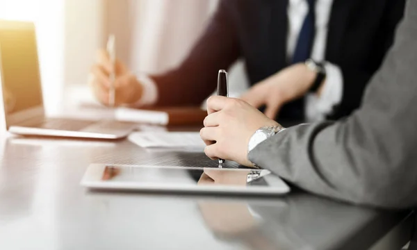 Empresarios y mujeres desconocidos sentados, usando computadora portátil y discutiendo preguntas en la reunión en la oficina soleada, de cerca. Concepto de éxito — Foto de Stock