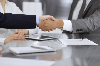 Başarılı bir müzakere olarak tokalaşma, yakın plan. Modern ofiste kontrat imzaladıktan sonra bilinmeyen iş adamları el sıkışıyor