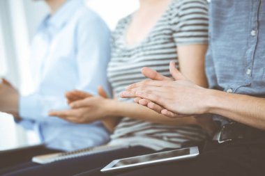 İş adamları toplantı ya da konferansta el çırpıyor. Modern beyaz ofisteki bir grup tanınmayan iş adamı ve kadın. Başarı takım çalışması, kurumsal koçluk ve alkış konsepti