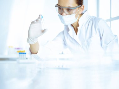 Kadın laboratuvar asistanı hastanede kan örneğini inceliyor. Tıp, sağlık ve araştırma konsepti