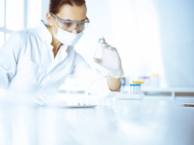 Kadın laboratuvar asistanı hastanede kan örneğini inceliyor. Tıp, sağlık ve araştırma konsepti