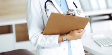 Klinikte çalışan kimliği belirsiz kadın doktor. Kadın doktor ilaç geçmişi ve tıbbi muayene sonuçlarını kontrol ediyor. Yakın plan. Tıp konsepti