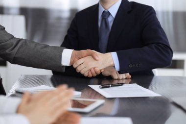 Başarılı bir müzakere olarak tokalaşma, yakın plan. Modern ofiste kontrat imzaladıktan sonra bilinmeyen iş adamları el sıkışıyor