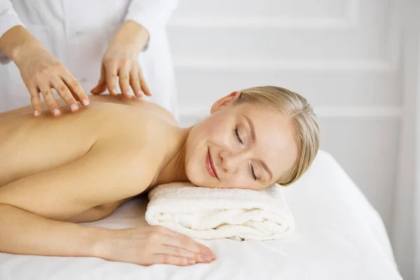 Hermosa mujer caucásica disfrutando de masaje de espalda con los ojos cerrados. Concepto de salón de belleza y spa — Foto de Stock