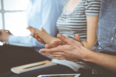 İş adamları toplantı ya da konferansta el çırpıyor. Modern beyaz ofisteki bir grup tanınmayan iş adamı ve kadın. Başarı takım çalışması, kurumsal koçluk ve alkış konsepti