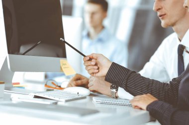 İş kadını ve erkek, modern ofiste bilgisayar ve bloknot kullanarak soruları tartışıyorlar. Yakın plan. İş dünyasında takım çalışması