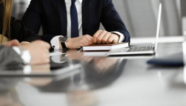 Meçhul iş adamları ve kadınlar modern ofiste oturuyorlar, çalışıyorlar ve sorularını tartışıyorlar.