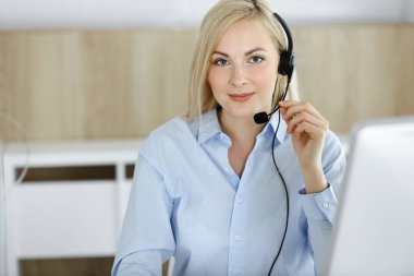 Sarışın bir iş kadını çağrı merkezinde kulaklıkla iletişim kuruyor. Telesellerin iş ya da ev işgali kavramı