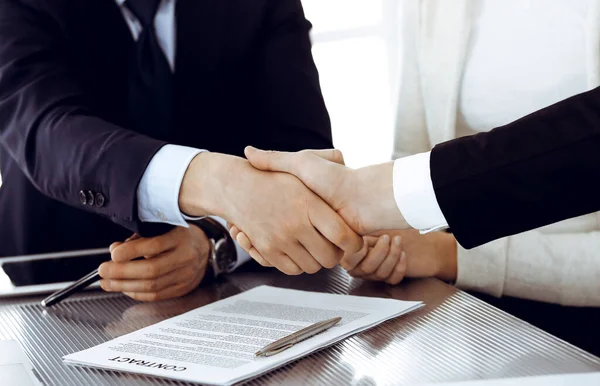 Üzletemberek kezet fognak, miután aláírták a szerződést a modern irodában. Csapatmunka, partnerség és kézfogás — Stock Fotó