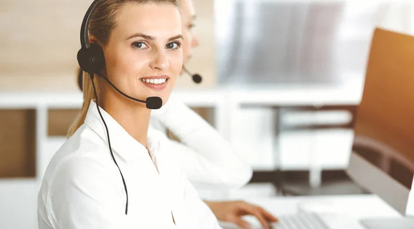 금발의 여성 고객 서비스 대표는 선선 사무실에서 헤드셋을 사용하여 온라인상의 고객과 상담하고 있다. 콜 센터 개념 — 스톡 사진