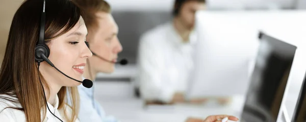 Grupo de operadores diversos en el trabajo en centro de llamadas. Hermosa mujer asiática sentada en auriculares en la oficina de servicio al cliente. Concepto empresarial —  Fotos de Stock