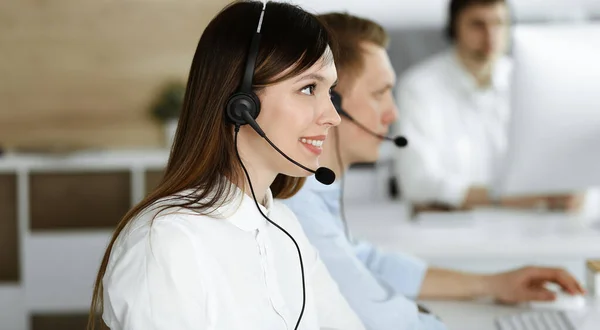 呼叫中心的一组不同的操作员在工作.美丽的亚洲女人坐在客户服务办公室的耳机里。业务概念 — 图库照片
