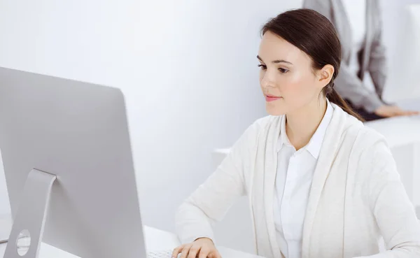 Mujer de negocios vestida casual que trabaja con computadora en la oficina. Abogado o contable en el trabajo —  Fotos de Stock