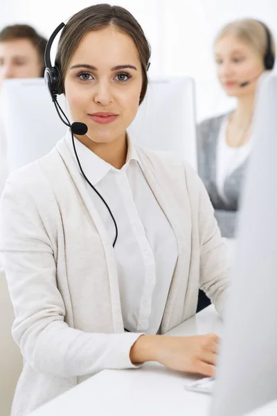 Centro de llamadas. Grupo de operadores diversos en el trabajo. Hermosa mujer en auriculares comunicándose con los clientes del servicio de telemarketing. Concepto empresarial —  Fotos de Stock