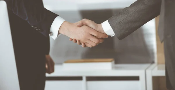 Neznámý podnikatel si potřásá rukou se svým kolegou nebo partnerem, když stojí zblízka rovně v moderní kanceláři. Skupina podnikatelů na schůzce — Stock fotografie