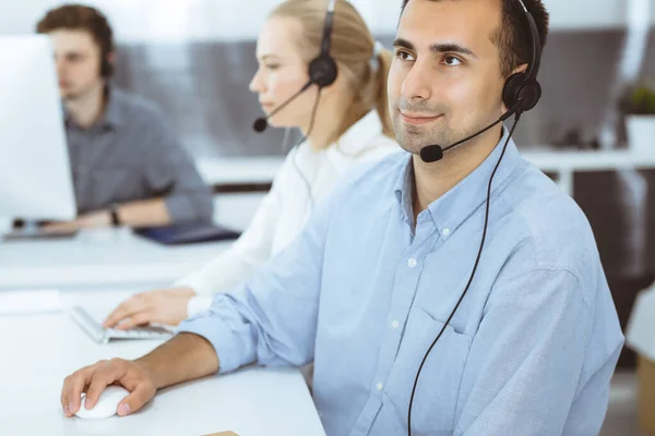 Call center. Group of casual dressed operators at work. Adult businessman in headset at customer service office. Telesales in business — Stock Photo, Image