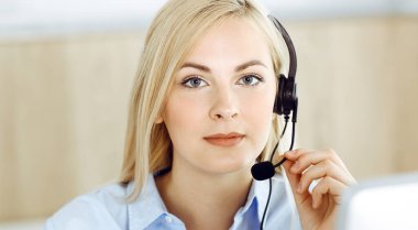Sarışın bir iş kadını çağrı merkezinde kulaklıkla iletişim kuruyor. Telesellerin iş ya da ev işgali kavramı