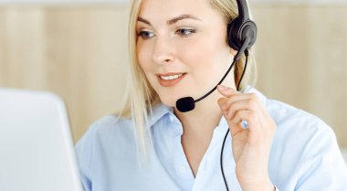 Sarışın bir iş kadını çağrı merkezinde kulaklıkla iletişim kuruyor. Telesellerin iş ya da ev işgali kavramı
