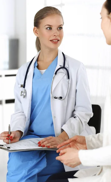 Mujer: el médico consulta a su paciente femenina mientras usa el portapapeles y el historial de medicamentos. Concepto de medicina — Foto de Stock