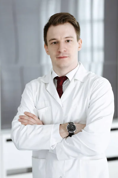 Doktor Mann Kopfschuss, während er im Krankenhausbüro steht. Arzt am Arbeitsplatz, Porträtfoto. Medizin und Gesundheitskonzept — Stockfoto
