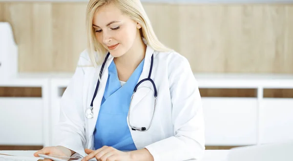 Kvinna-läkare som står på sjukhus eller klinik och använder tablettdator. Data och bästa service inom medicin och sjukvård — Stockfoto