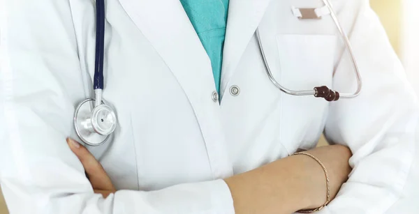 Onbekende vrouwelijke arts staat en houdt röntgenfoto in zonnige kliniek, close-up — Stockfoto