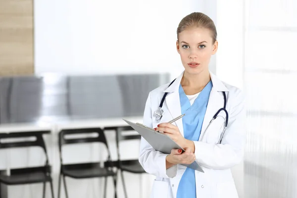Woman - doctor is using clipboard for filling up medication history record in clinic. Medicine concept — Stock Photo, Image