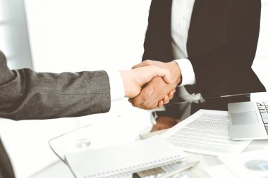 Bilinmeyen çeşitli iş adamları ofis masasındaki toplantıyı bitirmek için el sıkışıyorlar, yakın plan. El sıkışma kavramı
