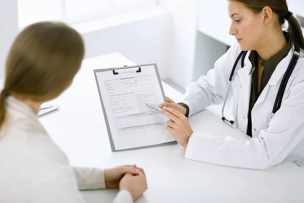 Ärztin und Patientin sitzen und sprechen in der Krankenhaussprechstunde. Grüne Bluse passt zum Therapeuten. Medizin und Gesundheitskonzept — Stockfoto