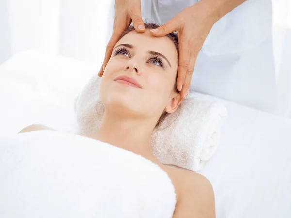 Mujer joven y rubia disfrutando de masajes faciales en el salón de spa. Concepto de belleza — Foto de Stock