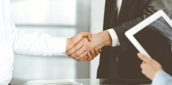 Onbekende diverse zakenmensen schudden elkaar de hand bij de ondertekening van contracten, close-up. Zakelijk en handdruk concept — Stockfoto