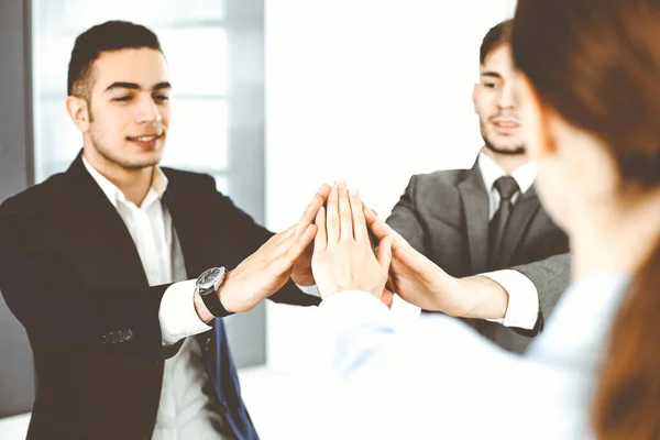 チームワークを発揮し、手を取り合い、現代のオフィスで互いに5つを与えるビジネスの人々グループ。成功の概念 — ストック写真