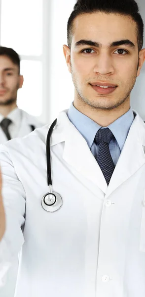 Arabische arts toont OK teken met duimen omhoog met Kaukasische collega in het medisch kantoor of kliniek. Diverse artsen team, beste behandeling, geneeskunde en gezondheidszorg concept — Stockfoto