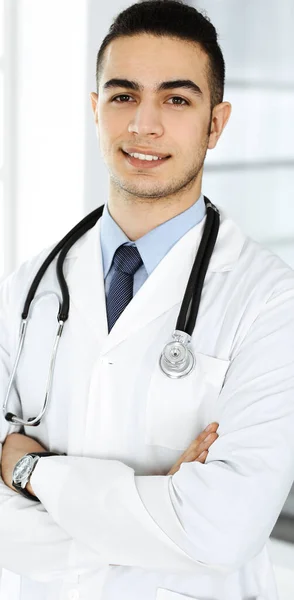 Arabische dokter man staat met gekruiste armen in de kliniek. Concept geneeskunde en gezondheidszorg — Stockfoto