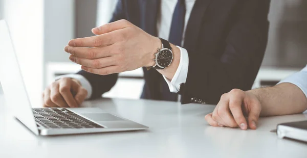 Gente de negocios desconocida usando computadora portátil en el escritorio en la oficina moderna. Empresario o empresario masculino está trabajando con su colega. Trabajo en equipo y concepto de asociación — Foto de Stock