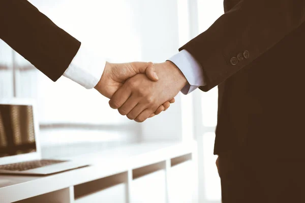 Businessman and woman shaking hands in office. Concept of handshake as success symbol in business — Stock Photo, Image
