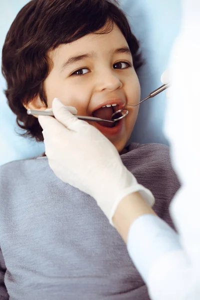 Mały arabski chłopiec siedzący na krześle dentystycznym z otwartymi ustami podczas wizyty u lekarza dentysty. Koncepcja stomatologii — Zdjęcie stockowe